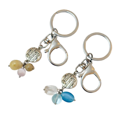 Dois porta-chaves metálicos com contas coloridas e medalha redonda com padrão