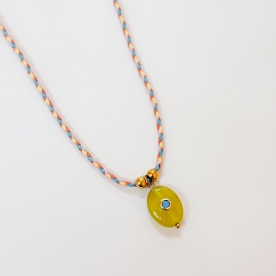 Colar com pingente amarelo e pedra azul em cordão trançado colorido.
