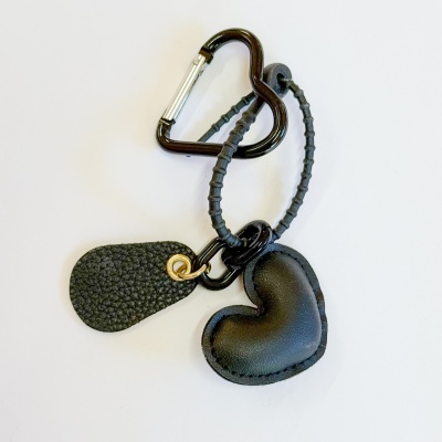 Porta-chaves com mosquetão preto, fio de borracha e pendentes de pele sintética em forma de coração.