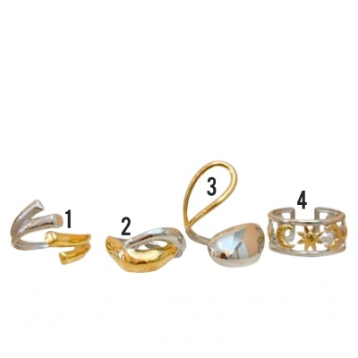 Quatro anéis em prata e dourado numerados sobre fundo branco