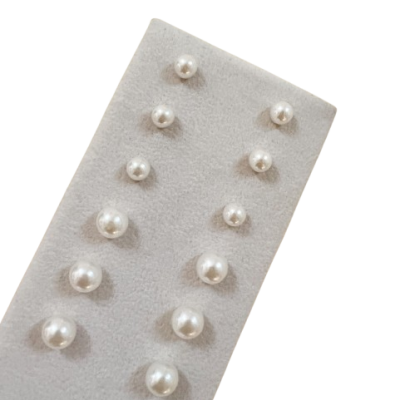 brincos de pérola em suporte cinza aterciopelado