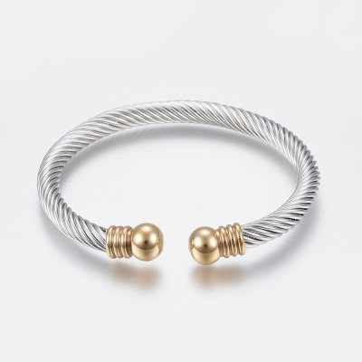 Pulseira aberta metálica prateada com detalhes dourados em fundo branco.