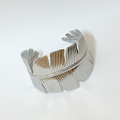 Pulseira prateada com design de folhas texturizadas sobre fundo branco