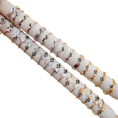 Conjunto de 30 anéis variados prateados e dourados em suportes de veludo.