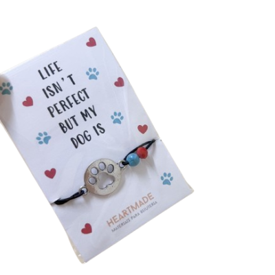 Pulseira com pendente em forma de pata de cão e cartão com texto e decoração em patinhas e corações.