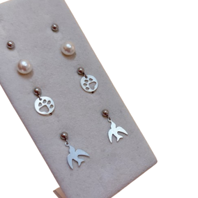 Conjunto de três pares de brincos prateados com perólas, patas de animal e pássaros
