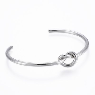 Pulseira aberta prateada com nó decorativo em fundo branco