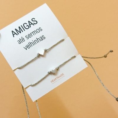 Conjunto de pulseiras cinzentas com coração prateado em cartão branco