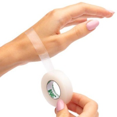 Fita adesiva 3M transparente em mão feminina com unhas cor de rosa