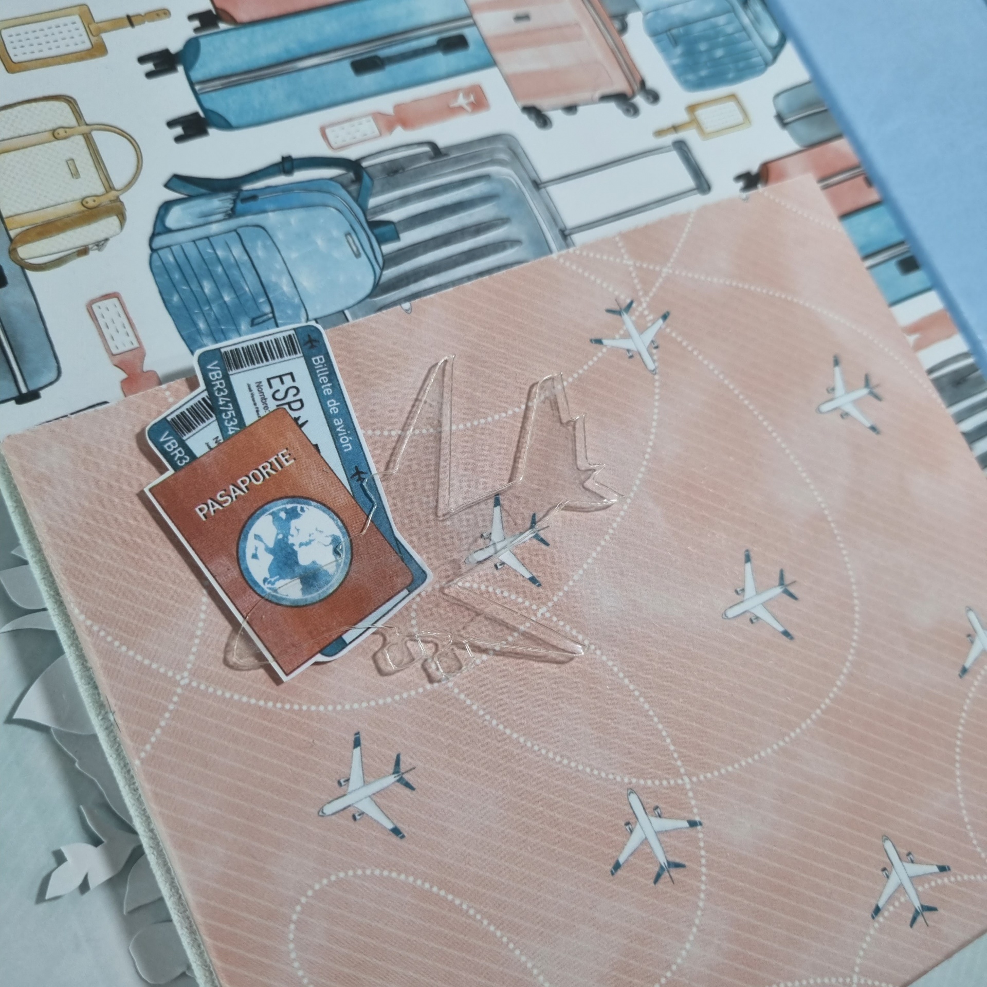 Papel estampado com malas, passaporte, cartões boarding pass e aviões em fundo cor de rosa
