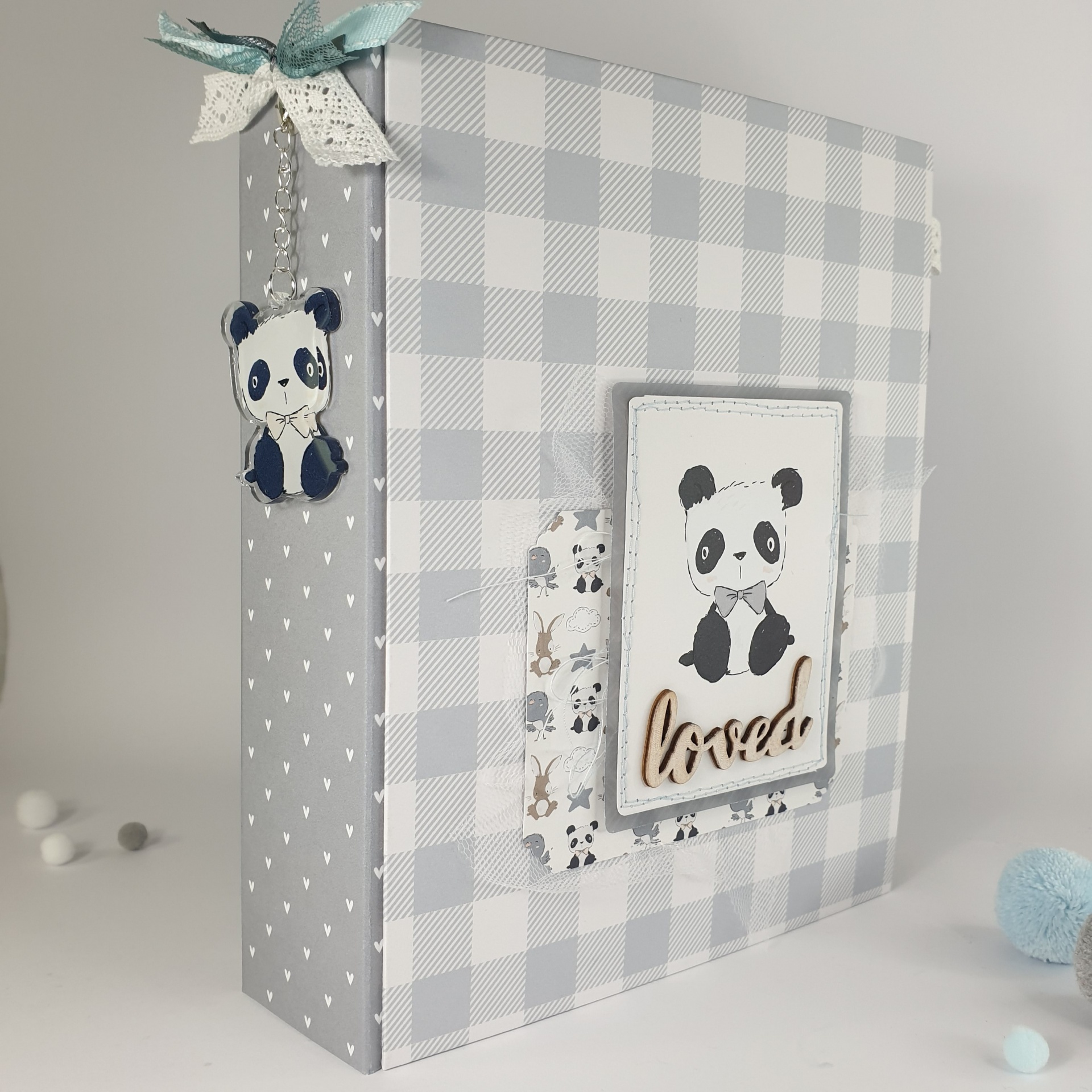 Álbum de fotos cinza com desenhos de pandas e laço azul