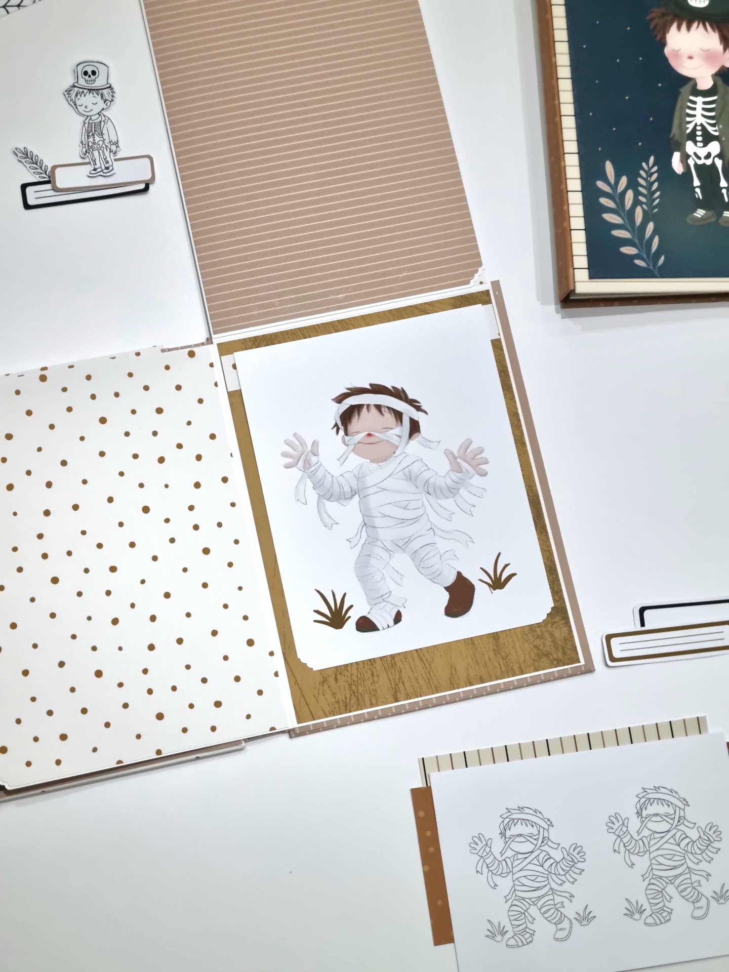 Folhas decorativas para scrapbook com desenhos de criança vestida de múmia, padrões de pontos castanhos e riscas finas.