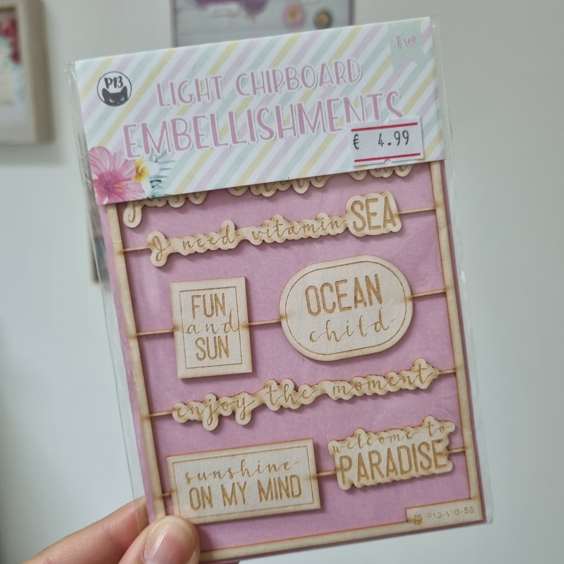 Embalagem de elementos decorativos em chipboard claro com texto recortado sobre fundo rosa