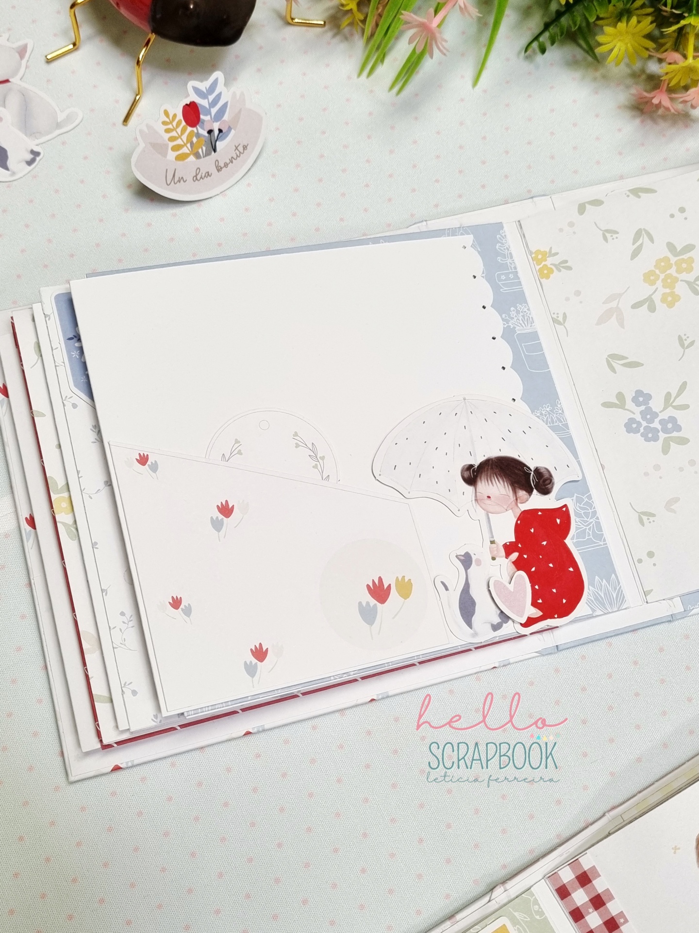 Página de scrapbook com ilustração de criança e gato e padrão floral