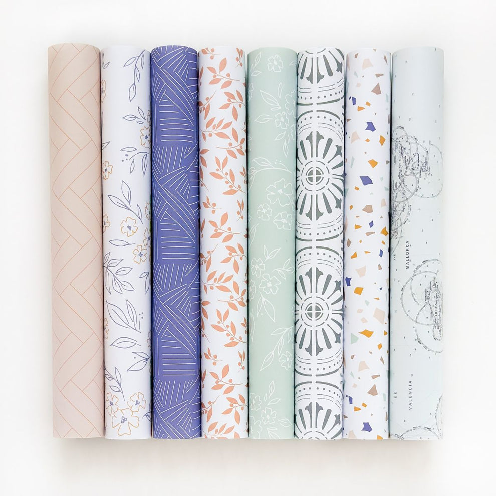 Oito rolos decorativos com diversos padrões coloridos alinhados lado a lado.