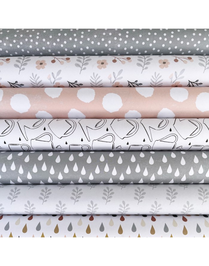 Rolos de tecido com padrões coloridos variados em cinza, branco e bege