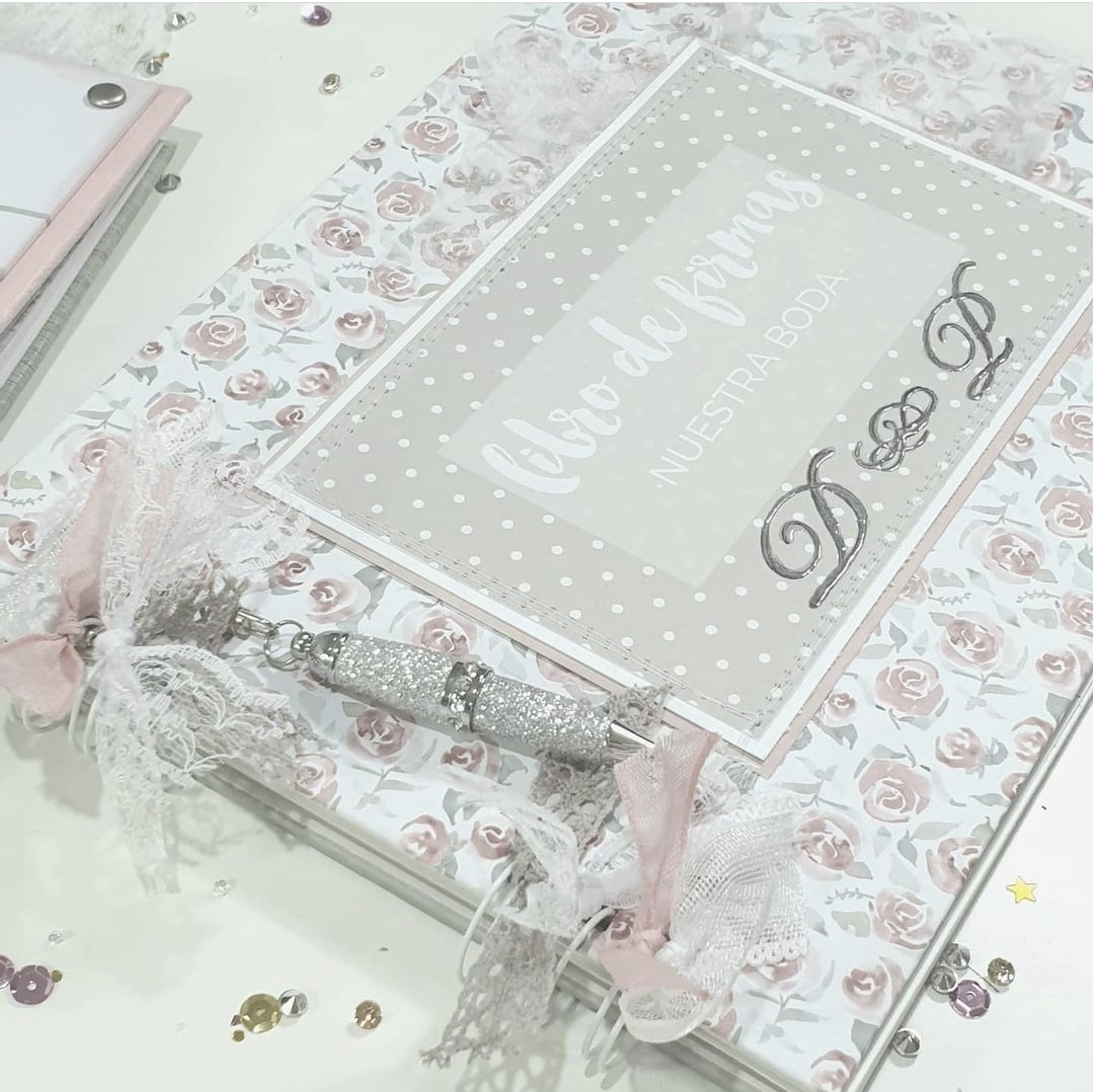 Livro de firmas decorado com flores cor de rosa e branco, com texto e laços de renda