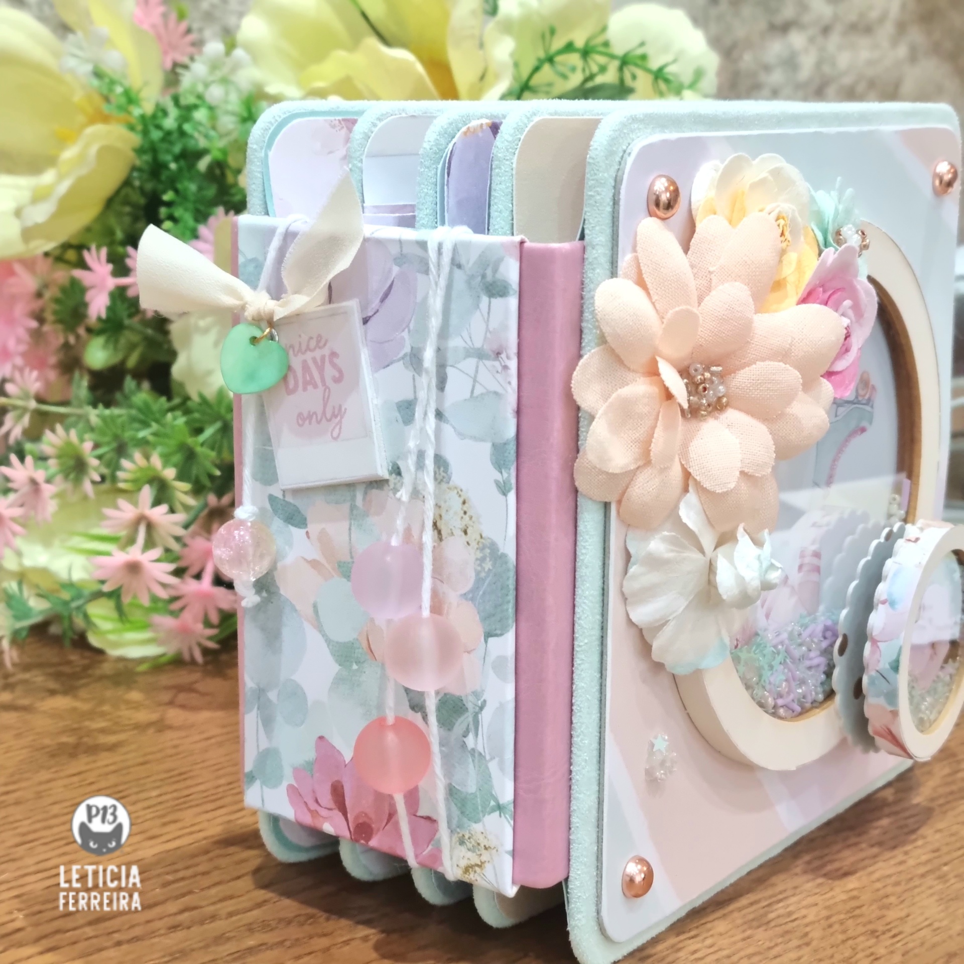 Conjunto de cadernos decorados com flores e padrões florais em tons pastel sobre superfície de madeira.