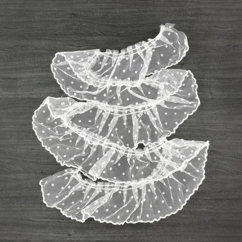 Faixas de tecido branco transparente com pontos em relevo sobre fundo escuro