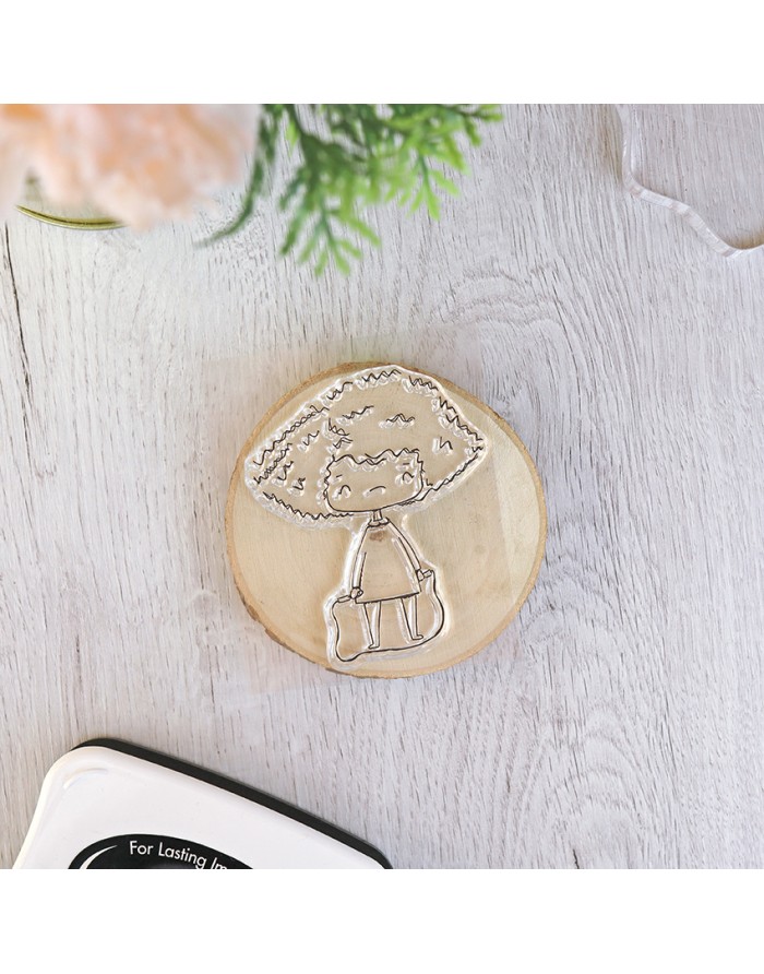 Carimbo de borracha com desenho de personagem sobre base de madeira redonda