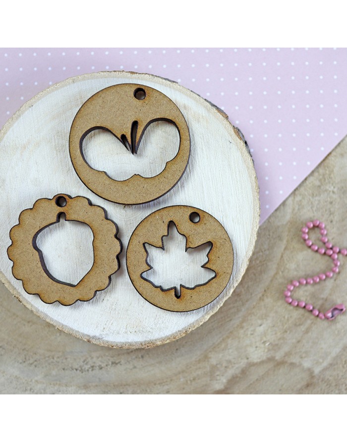 Três etiquetas decorativas de madeira com recortes variados sobre base de madeira clara