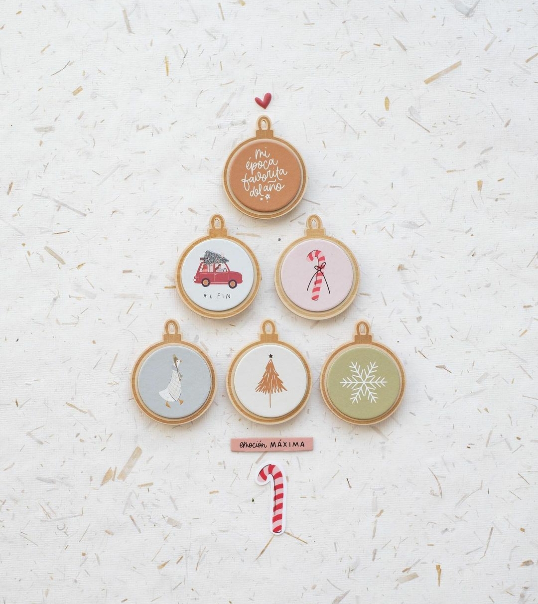 Anéis de bordado com desenhos e cores variados numa disposição de árvore de Natal