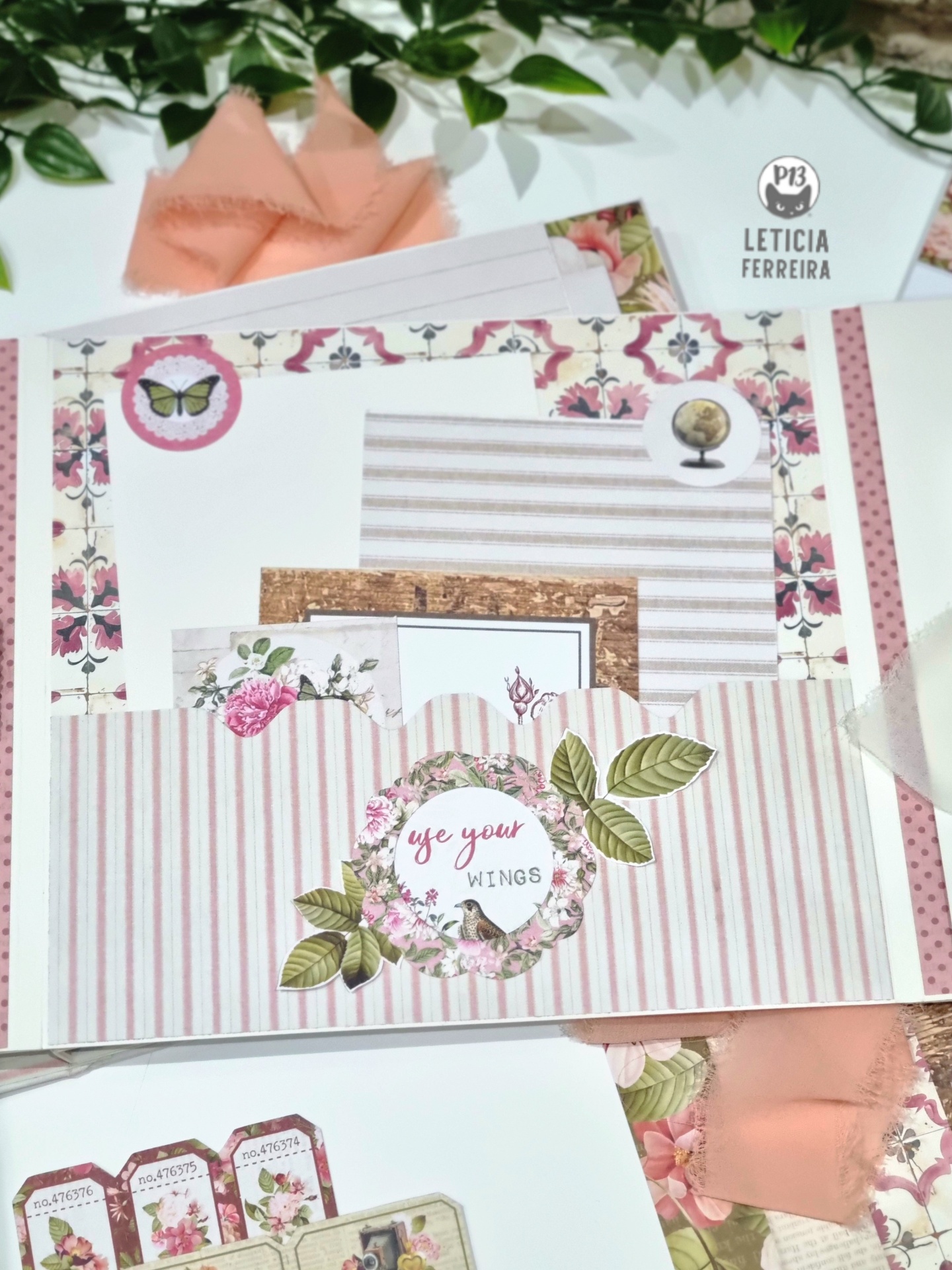 Conjunto de papelaria com padrões florais, listras rosa e branco, e cartões decorativos com texto 'use your WINGS'.