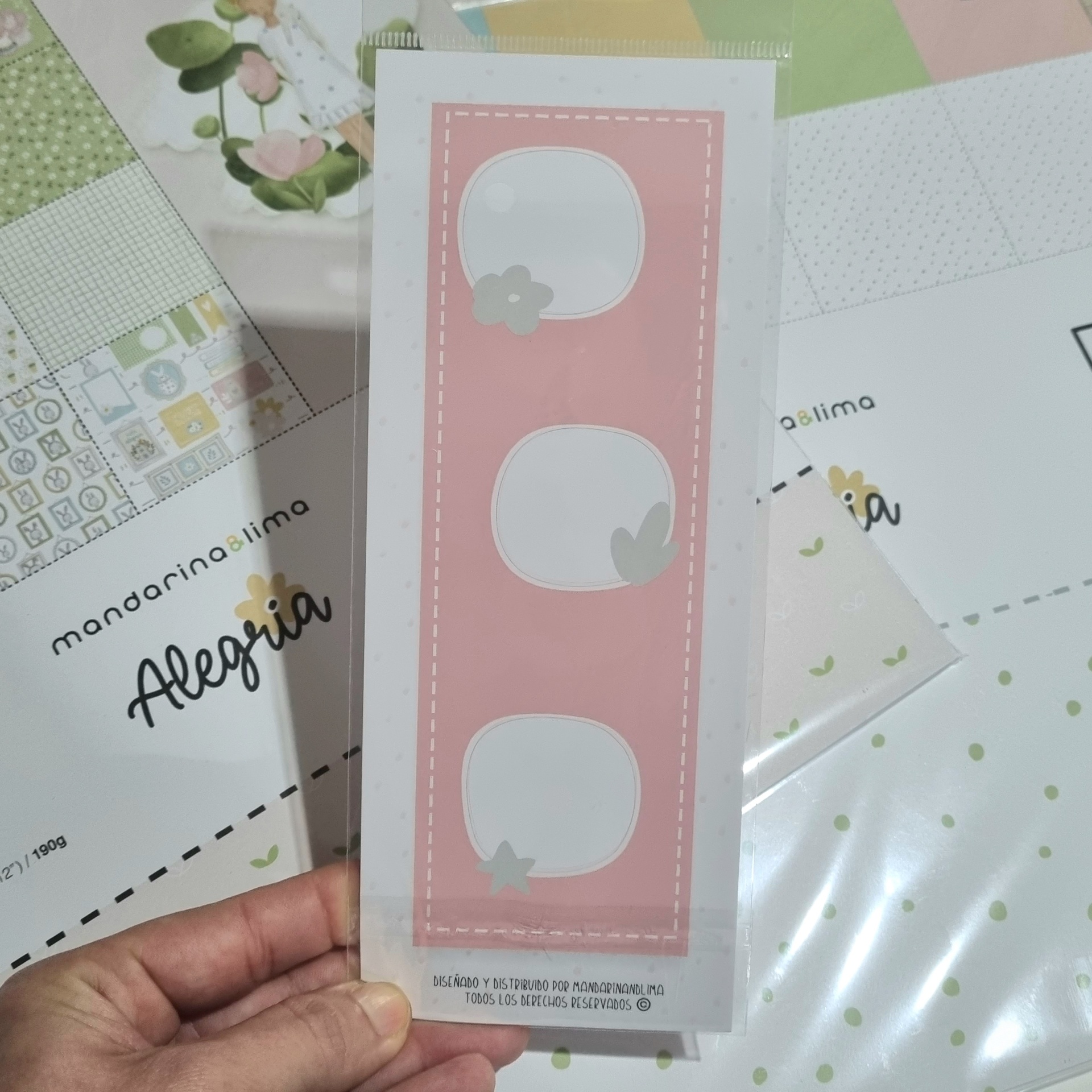Marcador de página rosa com três espaços brancos decorados, papéis de scrapbooking ao fundo