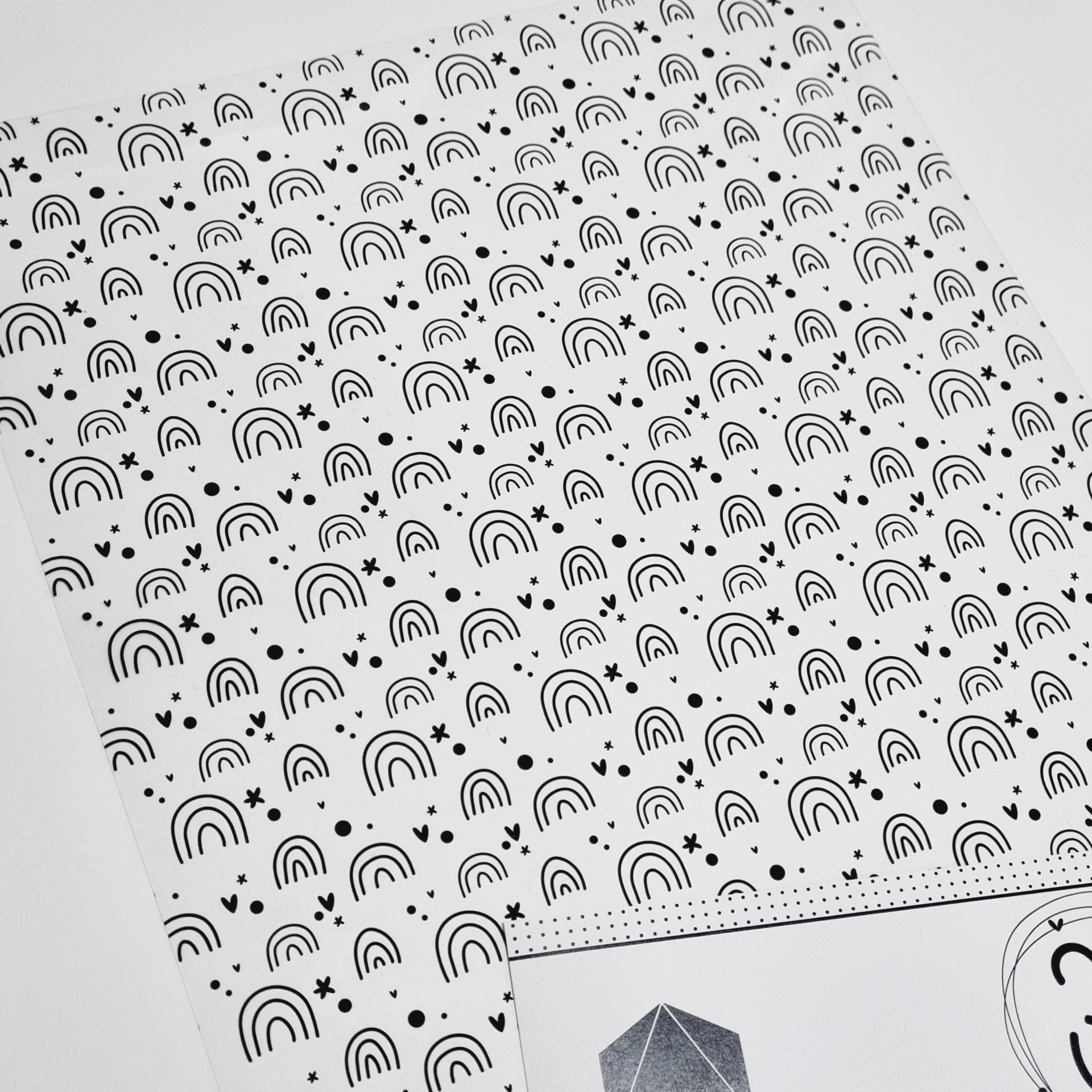 Papel branco com padrão de arcos pretos e cartão com imagem geométrica