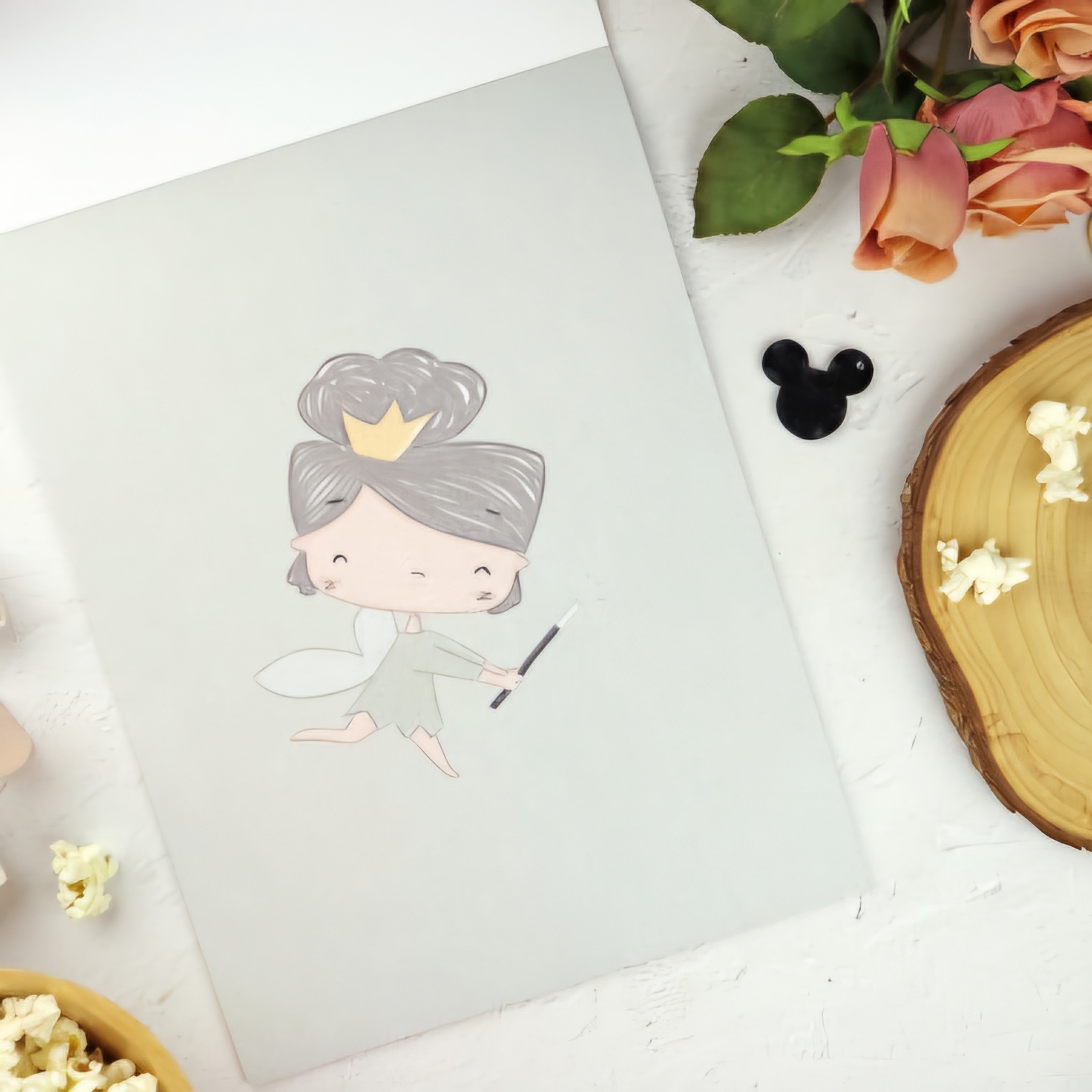 Caderno cinzento com ilustração de fada e elementos decorativos ao redor