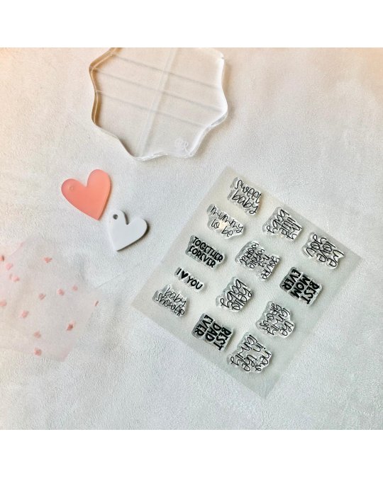 Kit de carimbos de silicone com corações e folha transparente sobre tecido branco.