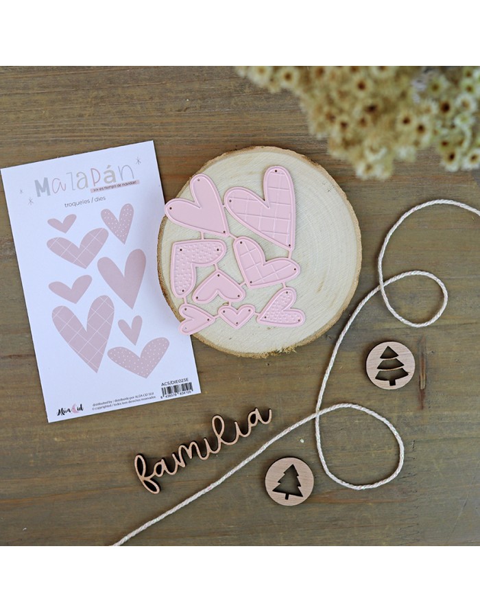 Conjunto decorativo com recortes de corações rosa, madeira redonda, cordão branco, peças com árvore e palavra 'familia' em madeira