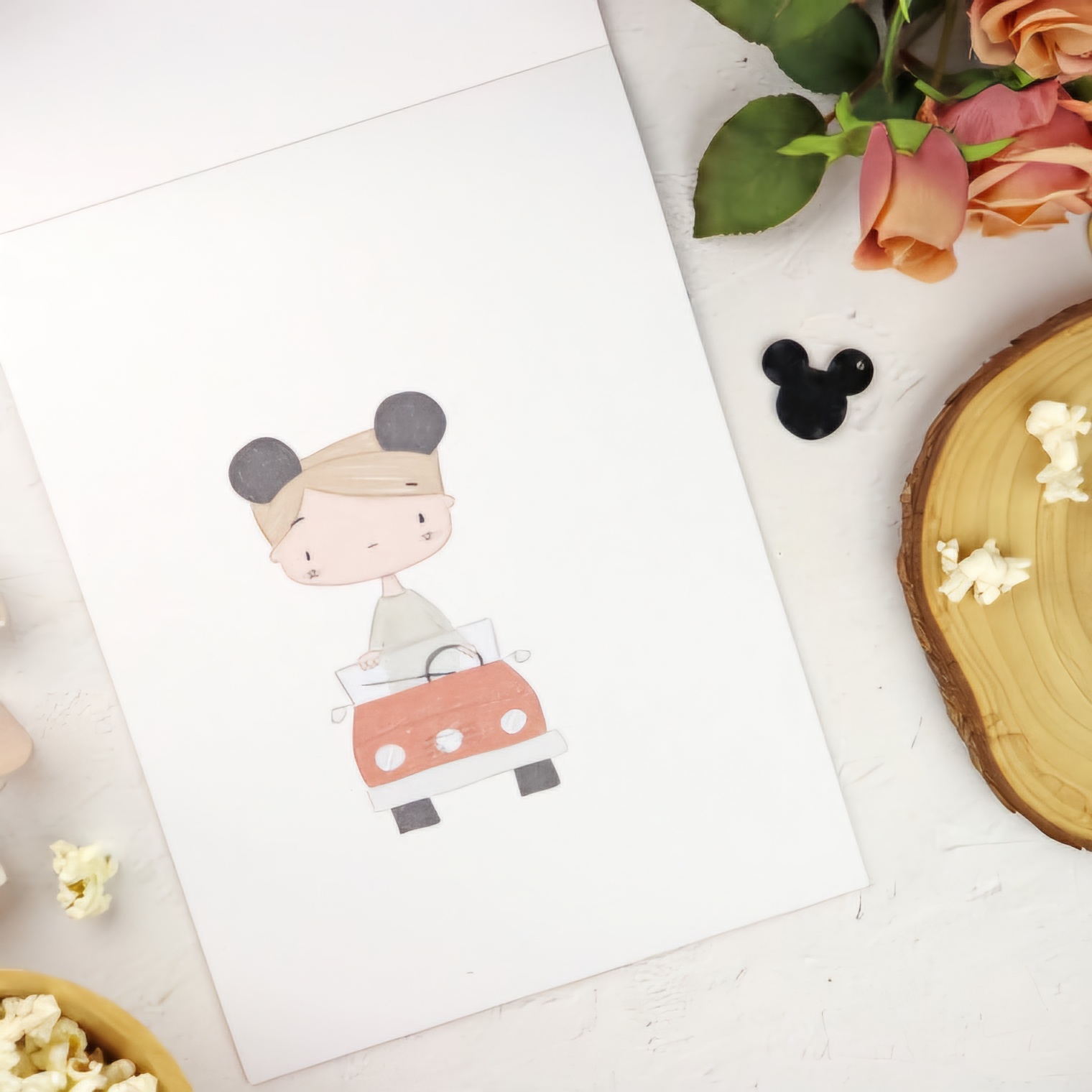 Cartão branco com ilustração de criança num carro vermelho, flores cor-de-rosa e madeira ao lado