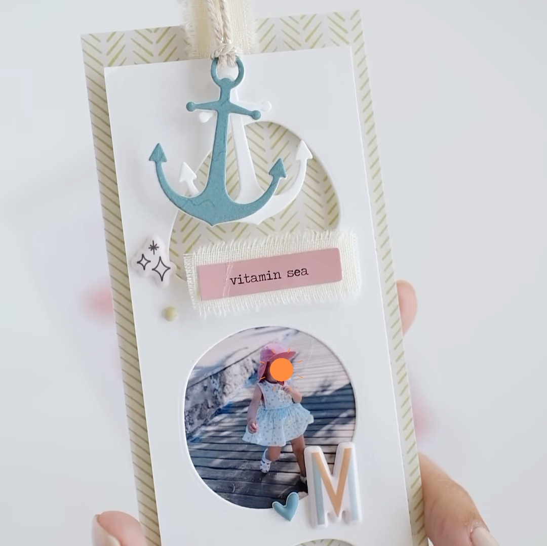 Marcapáginas decorado com âncora azul, etiqueta 'vitamin sea' e foto de criança de costas