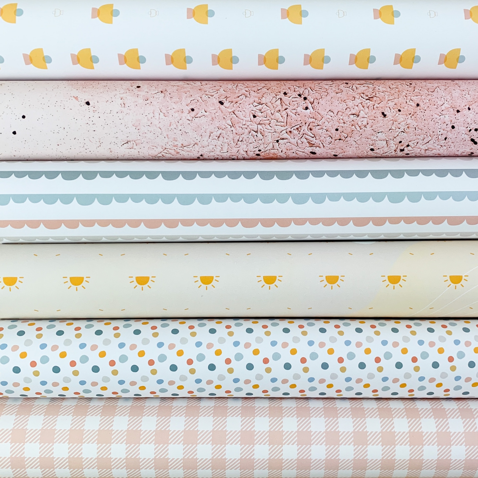 Tecidos coloridos empilhados com padrões diversos em tons pastel