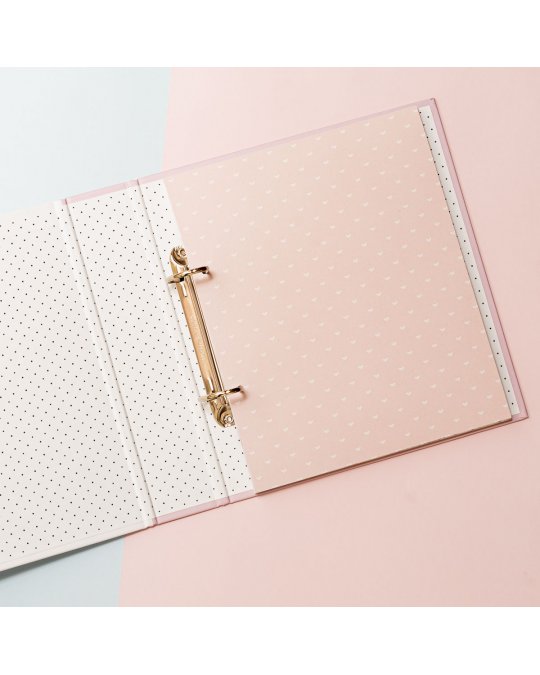 Pasta de argolas rosa claro com pontos e interior branco com pontos, em fundo azul claro e rosa