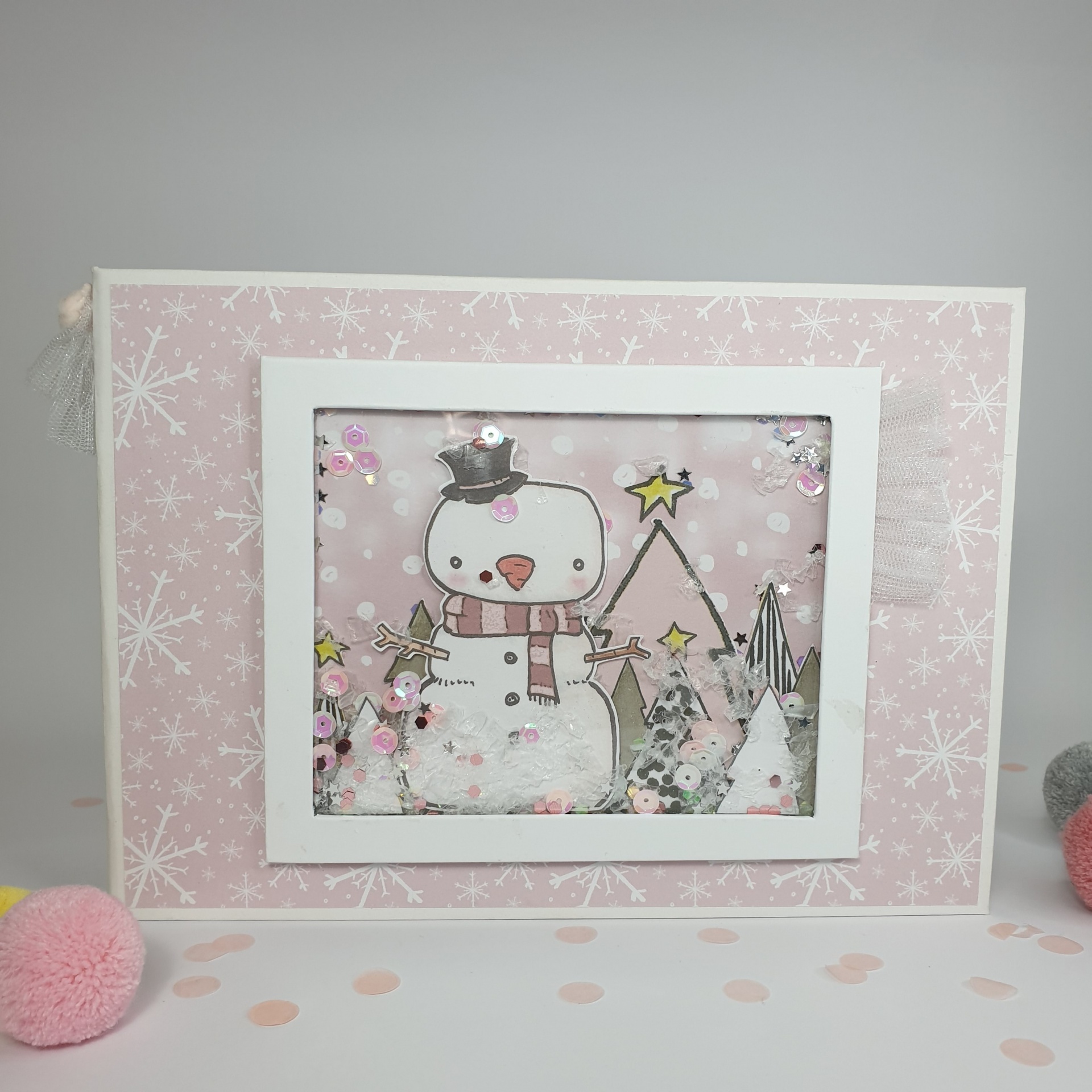 Quadro decorativo com boneco de neve e árvores em fundo rosa com flocos de neve