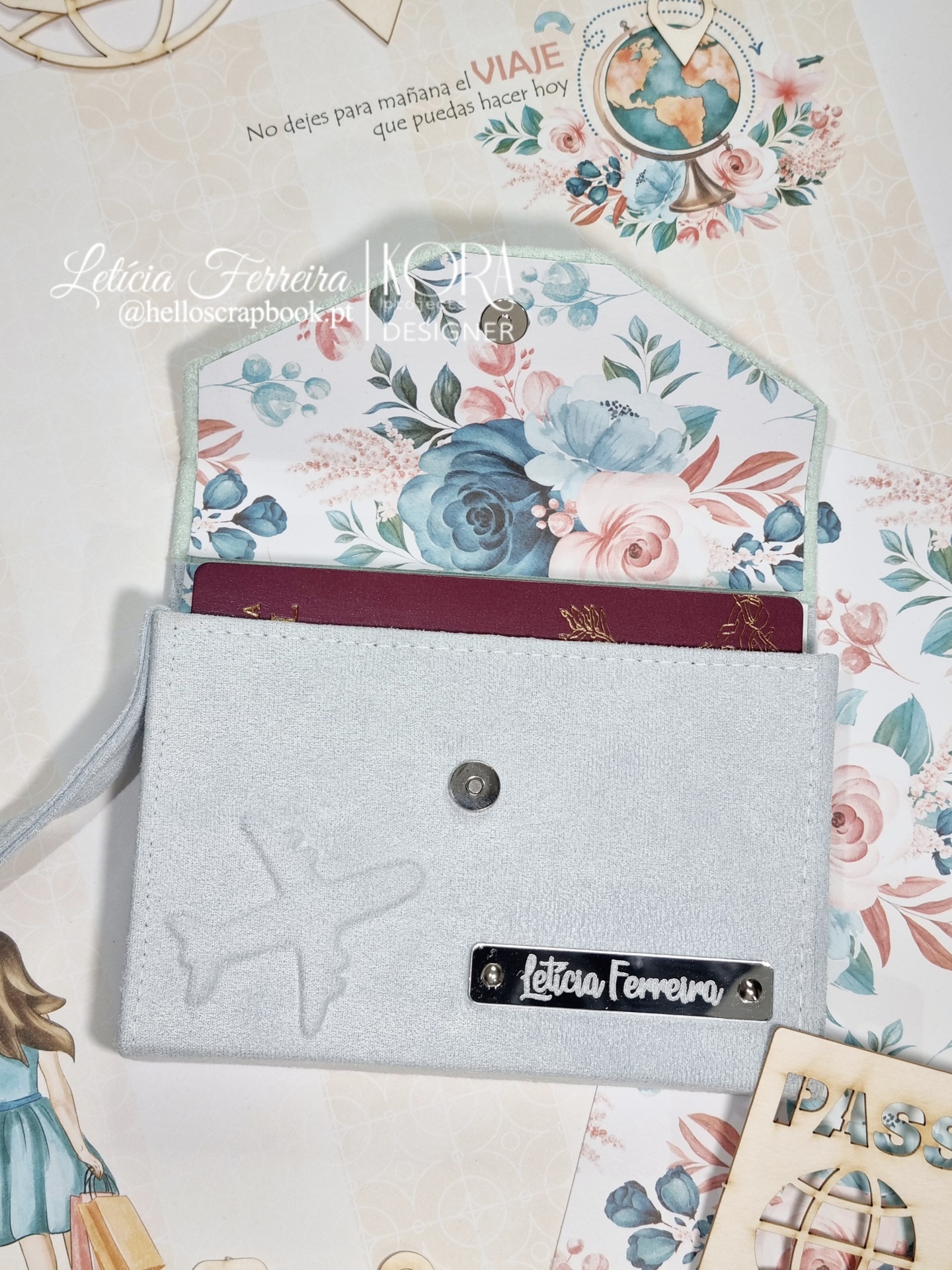 Carteira cinza claro com padrão floral no interior e passaporte vermelho visível