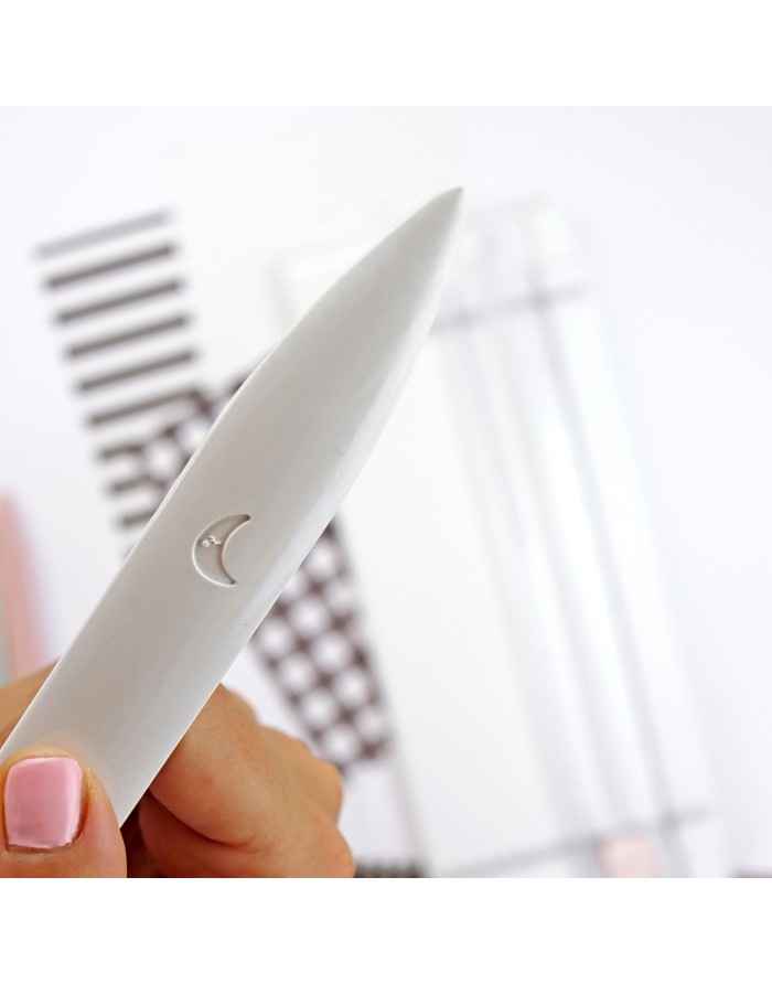 caneta branca com símbolo de lua e fundo geométrico desfocado