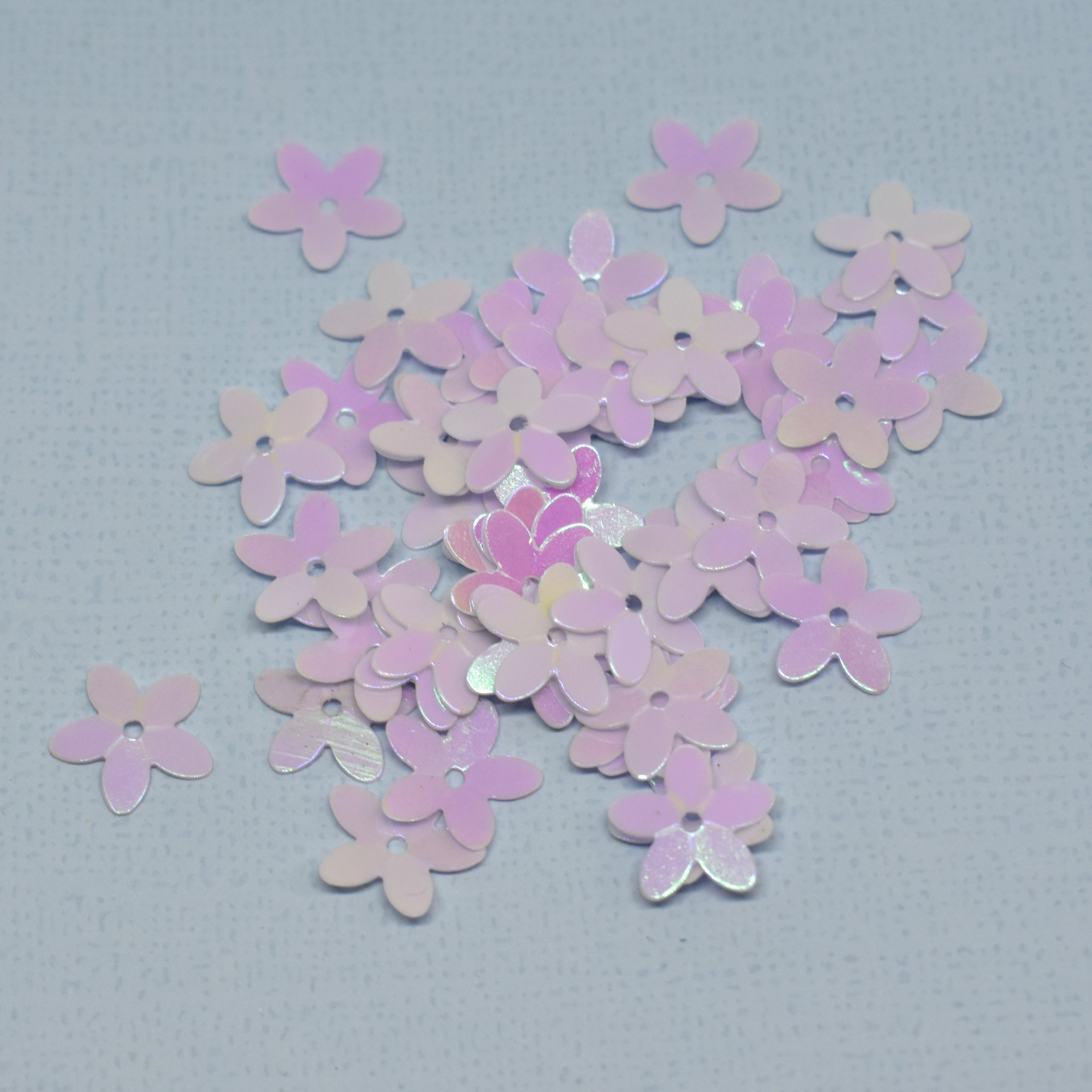 Adereços de flores rosa peroladas sobre superfície cinzenta