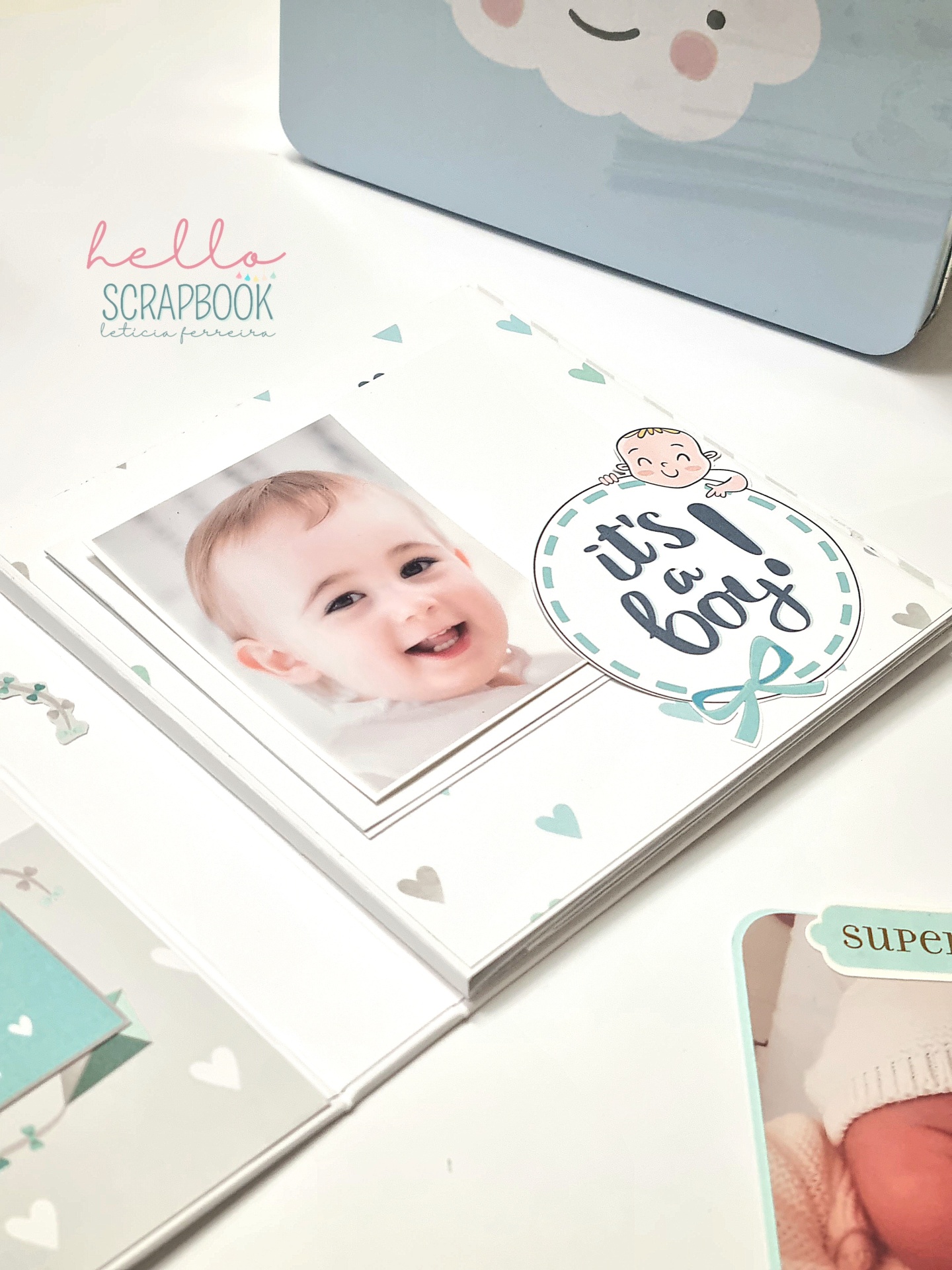 scrapbook com fotos de bebés e decoração azul com texto 'it's a boy!'
