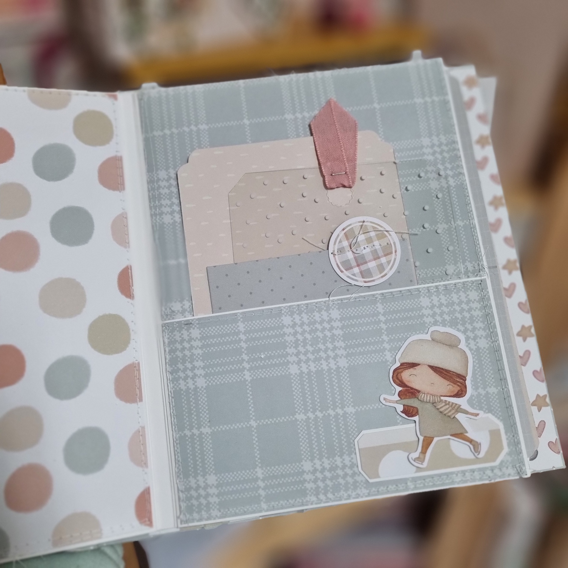 Página decorada de álbum com padrão xadrez, etiquetas em relevo e ilustração de menina com gorro