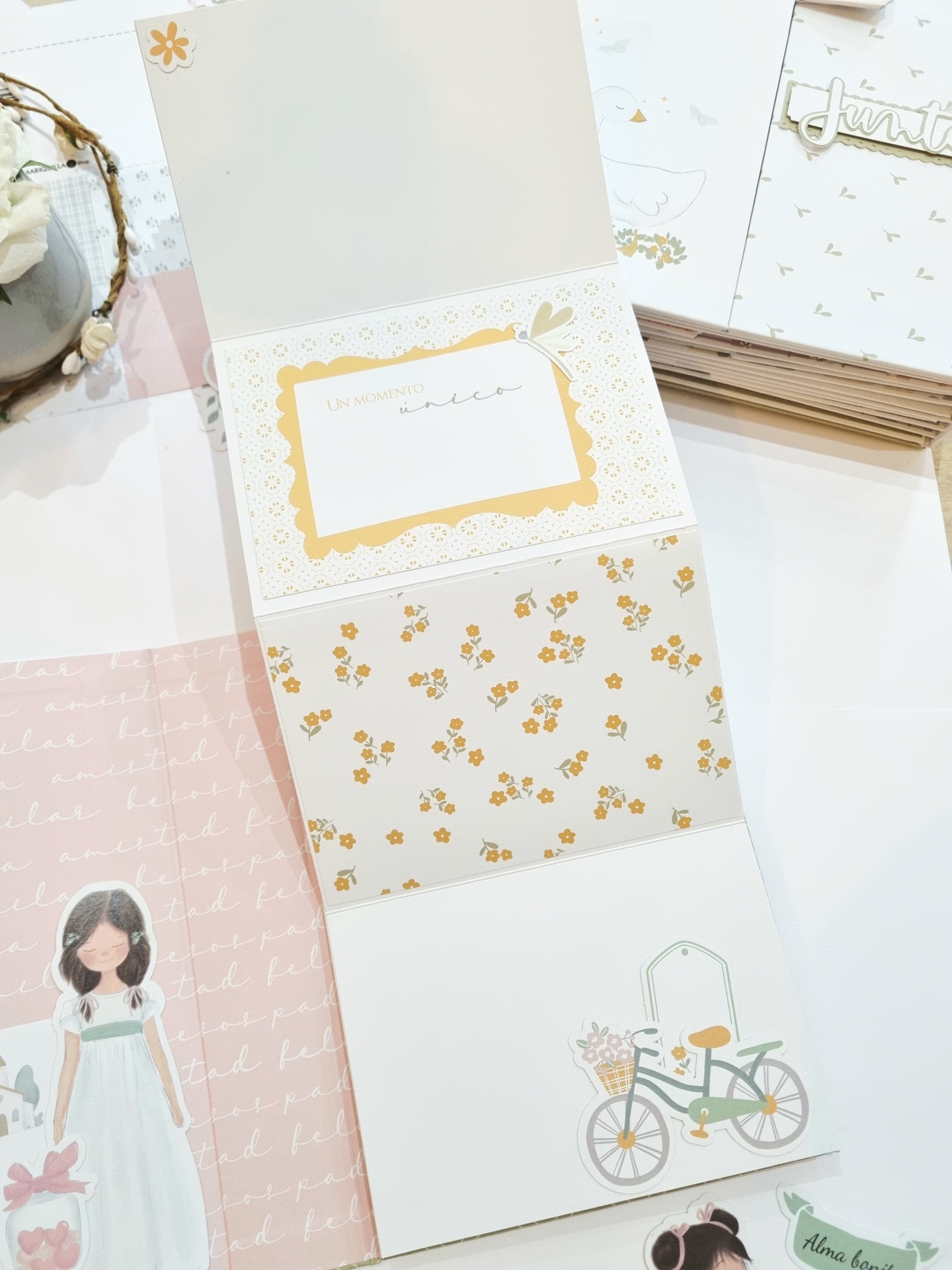 Livro de recortes com decoração floral amarela e ilustrações de menina e bicicleta
