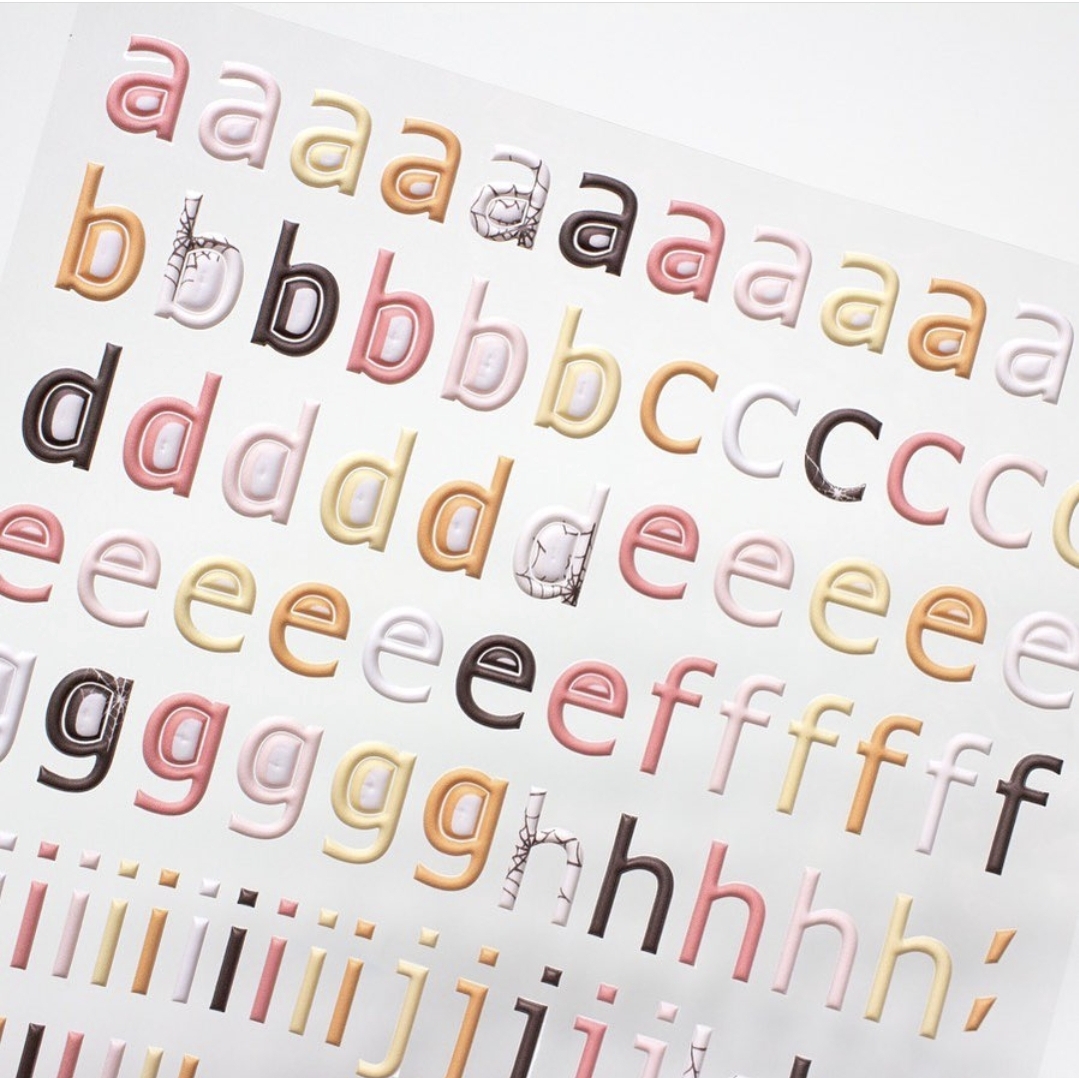 Folha com autocolantes de letras minúsculas coloridas e decoradas
