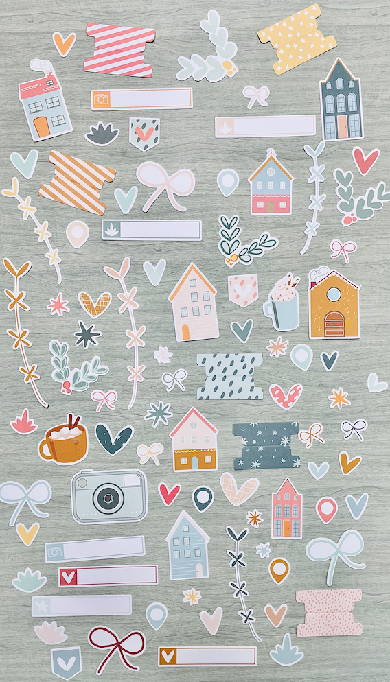 Autocolantes coloridos com temas de casas e corações num fundo de madeira clara