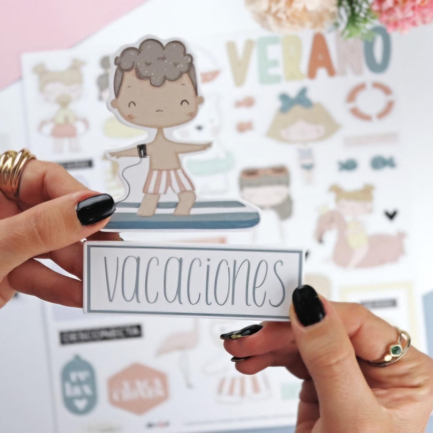 Piece cutout with cartoon child on paddleboard and word 'vacaciones' held by hands