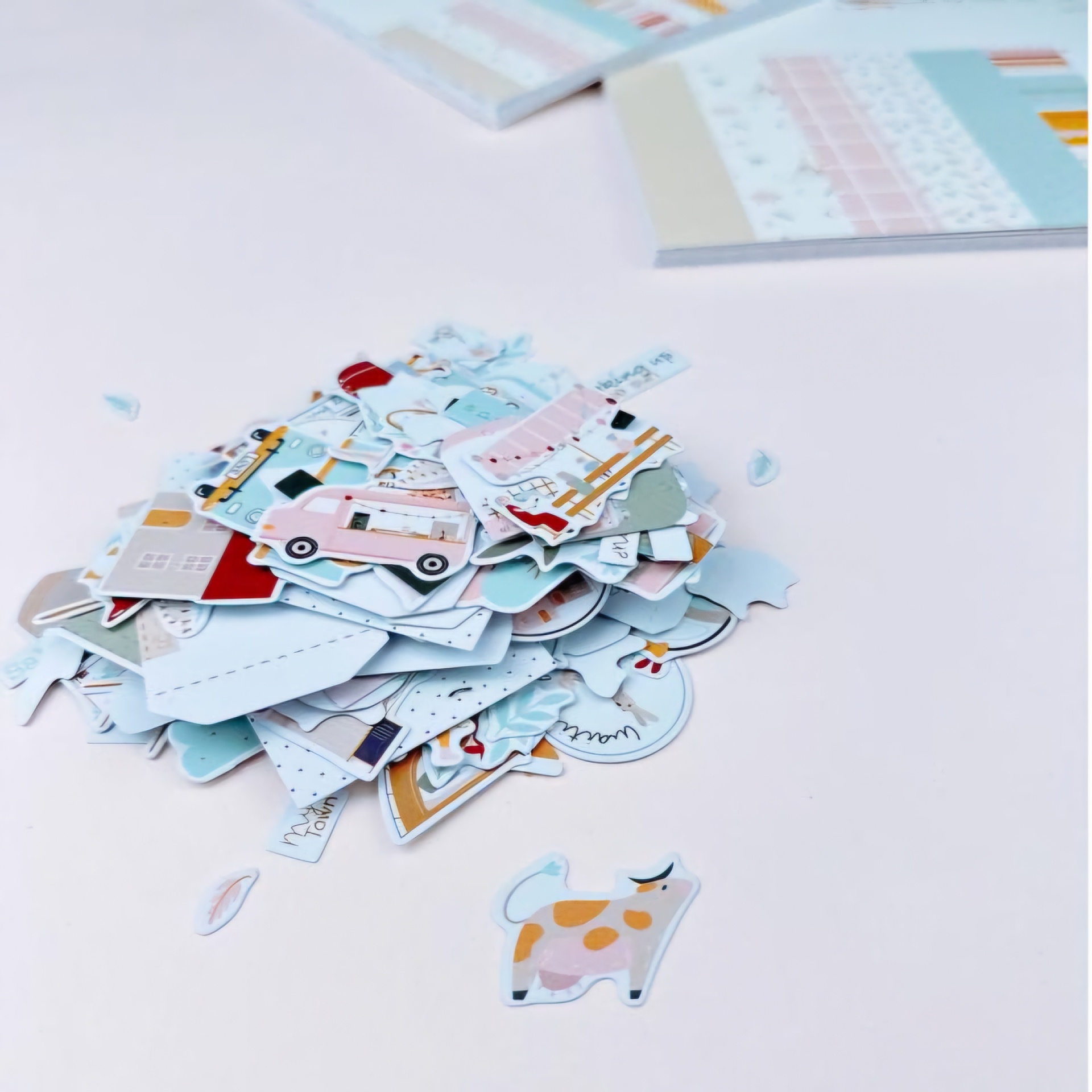 Conjunto de recortes de papel coloridos variados sobre superfície branca