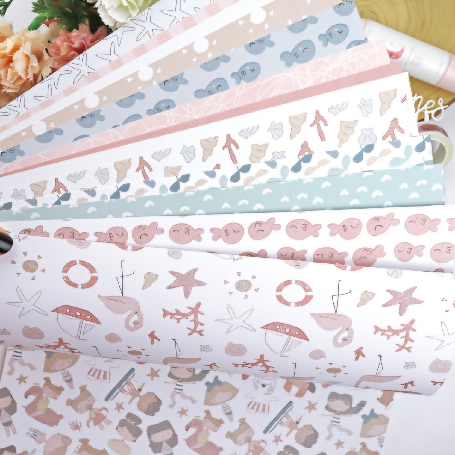 Folhas de papel decorativo com estampas marinhas em cores suaves