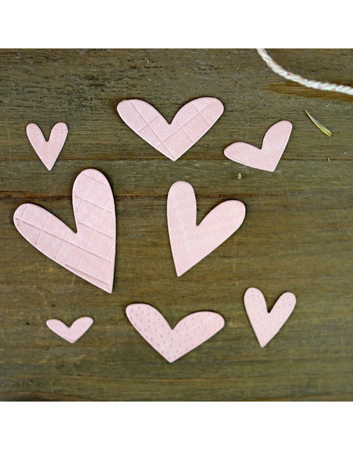 Sete corações cor-de-rosa de papel em várias texturas sobre madeira