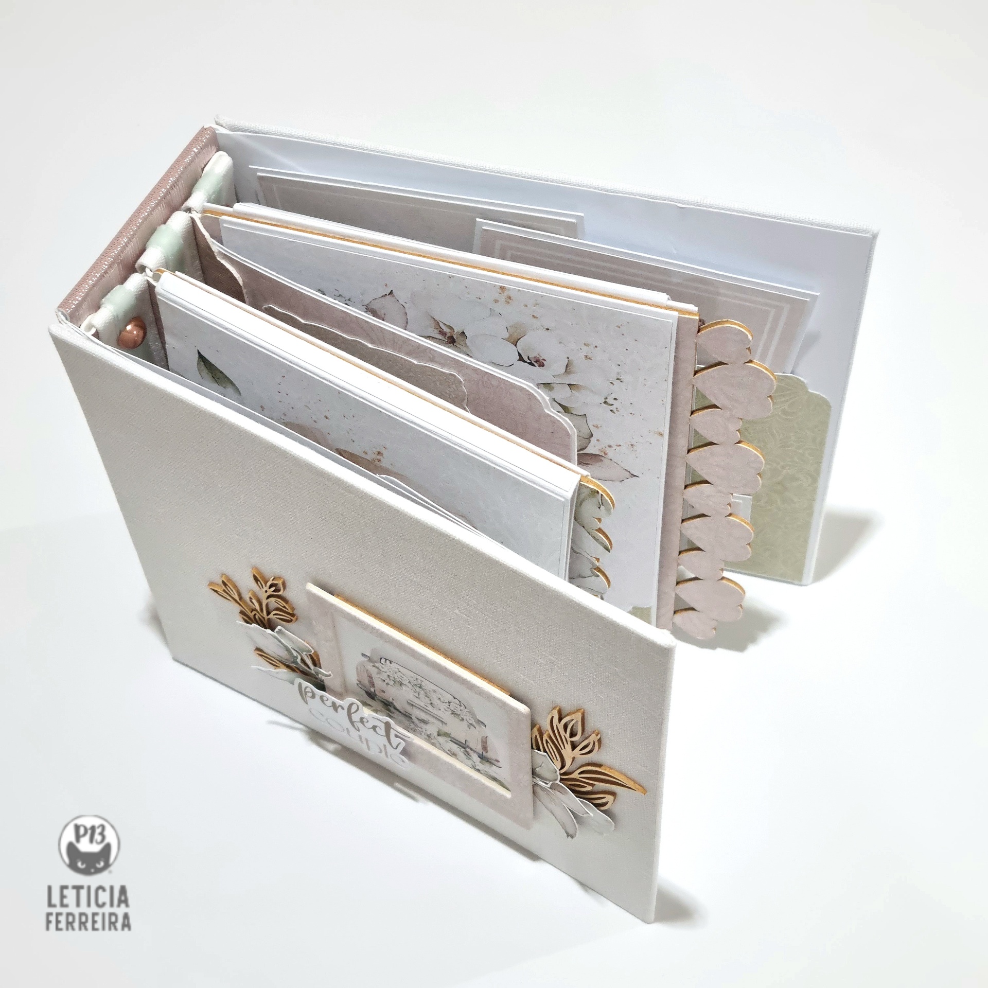 Álbum de scrapbook branco com decoração em madeira e páginas decoradas